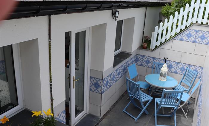 Steps up to secure garden, more gentle steps on other side of Cottage. Back Door leads into Kitchen/Diner from parking area. Lighting for the evening.